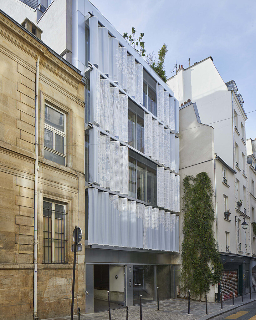 uvnitř venku zahaluje nová pařížská budova s ​​perforovanou textilní fasádou