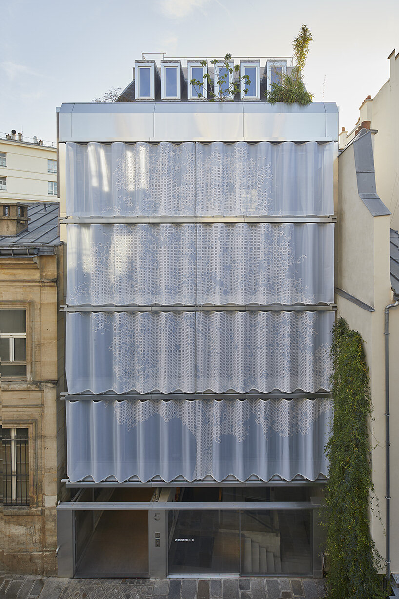 uvnitř venku zahaluje nová pařížská budova s ​​perforovanou textilní fasádou