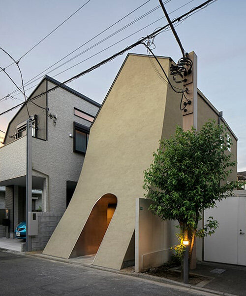a sweeping introverted facade shelters a manga artist's split-leveled home studio in tokyo