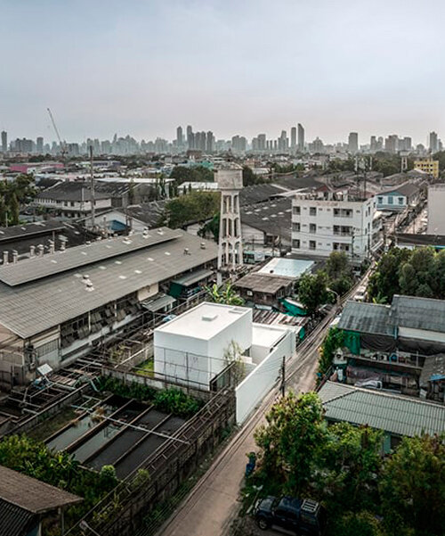 white dense geometric block pops out of urban bangkok neighborhood