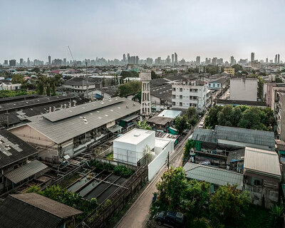 white dense geometric block pops out of urban bangkok neighborhood