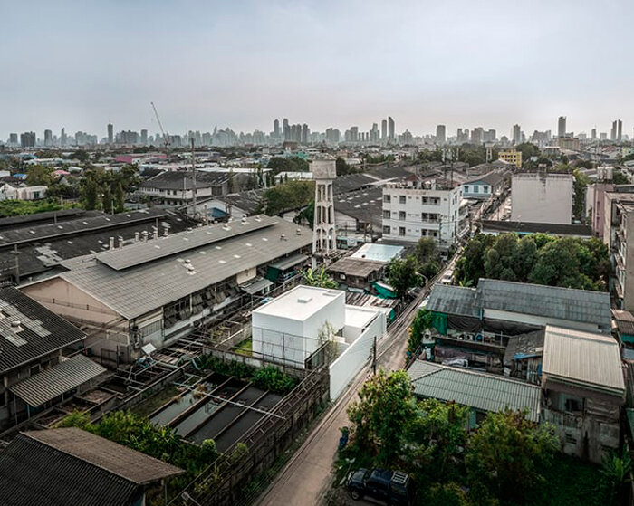 white dense geometric block pops out of urban bangkok neighborhood