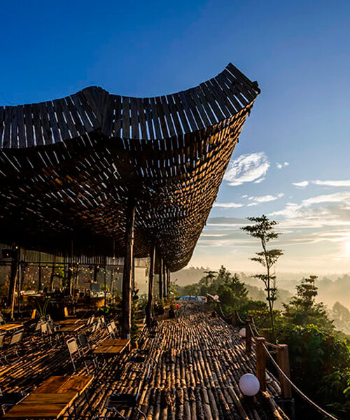 perforated wooden roof drapes over outdoor café in vietnamese rural landscape