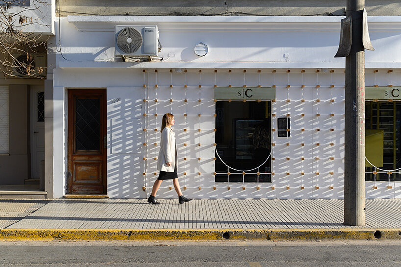 EFEEME arquitectos uplifts bakery façade in argentina with smooth iron and wooden props