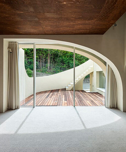 'spline' house's smooth curves frame forest backdrop in osaka