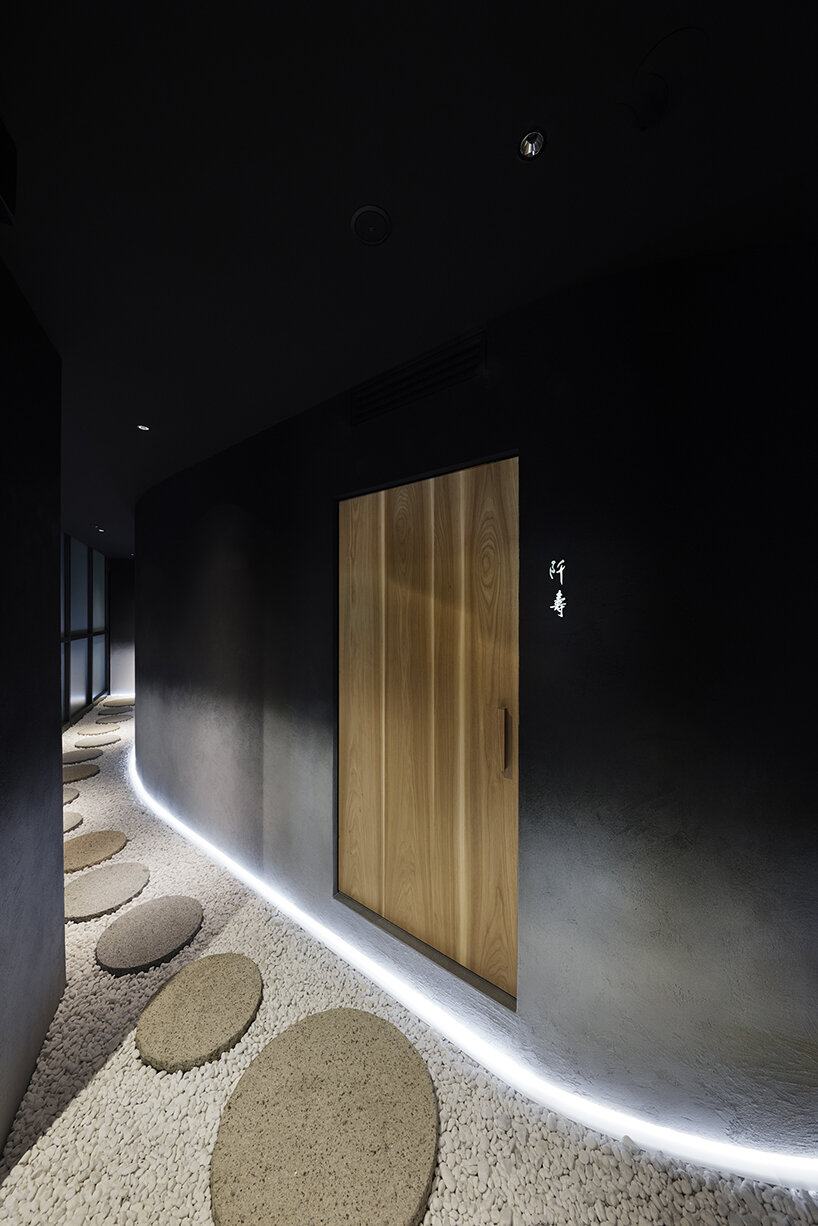 black-ink walls and dim lighting engulf this members-only sushi restaurant in tokyo