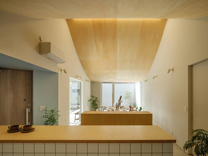 vaulted ceiling drapes over peaceful house + café by mikaduki architects in japan