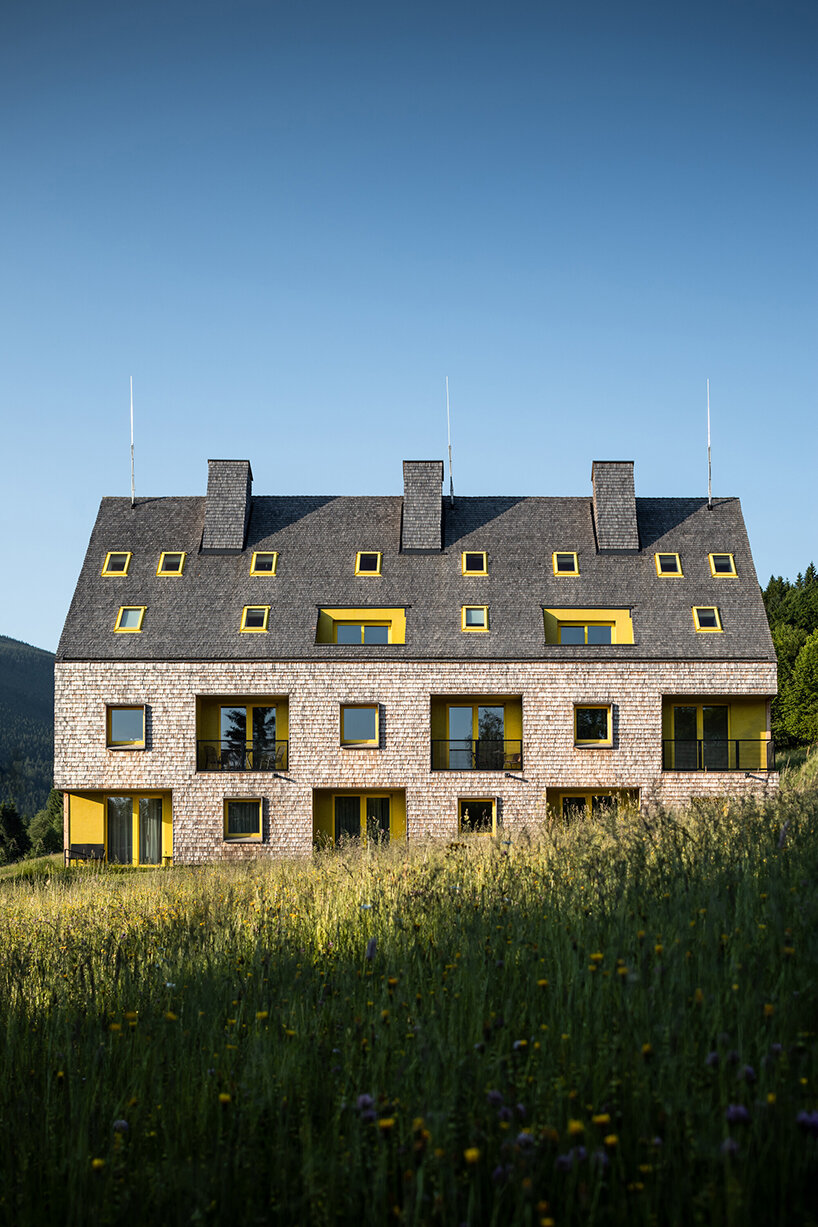 a mosaic of colored voids & glass adorns new apartment buildings in the czechian mountains