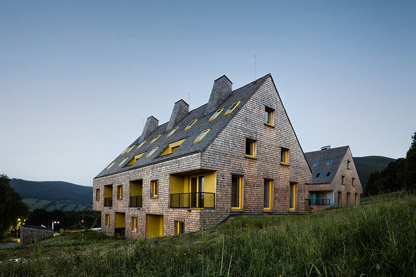 a mosaic of colored voids & glass adorns new apartment buildings in the czechian mountains