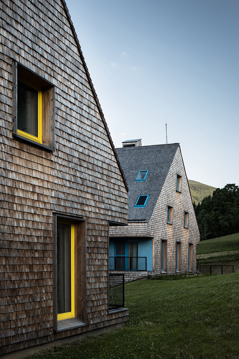 a mosaic of colored voids & glass adorns new apartment buildings in the czechian mountains