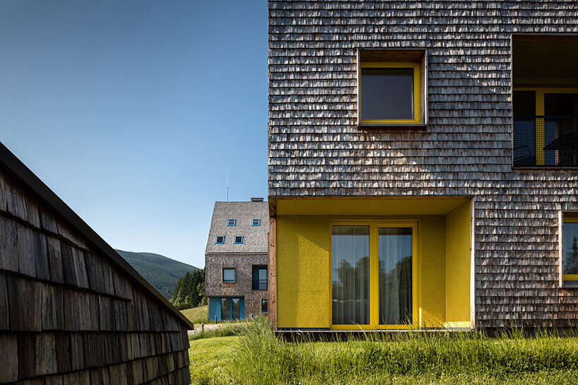 a mosaic of colored voids & glass adorns new apartment buildings in the czechian mountains