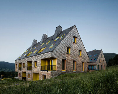 a mosaic of colored voids & glass adorns new apartment buildings in the czechian mountains