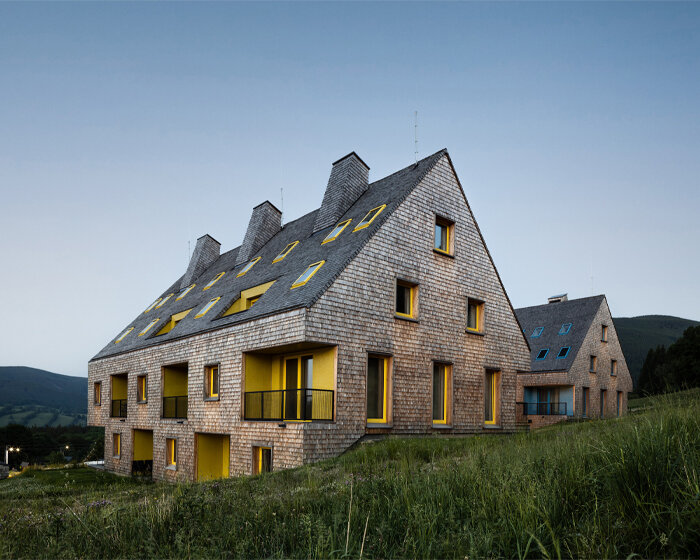 a mosaic of colored voids & glass adorns new apartment buildings in the czechian mountains