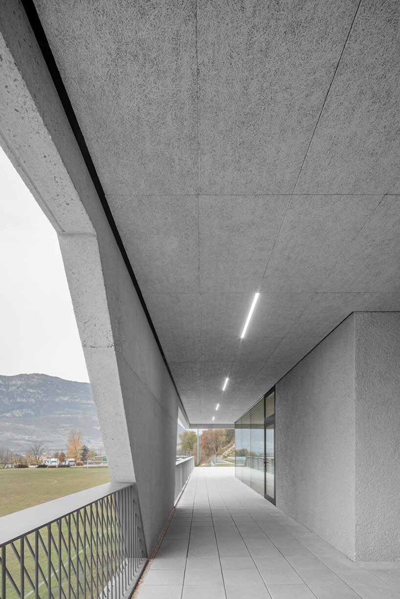 modusarchitects' long concrete sports center divides italian mountain
