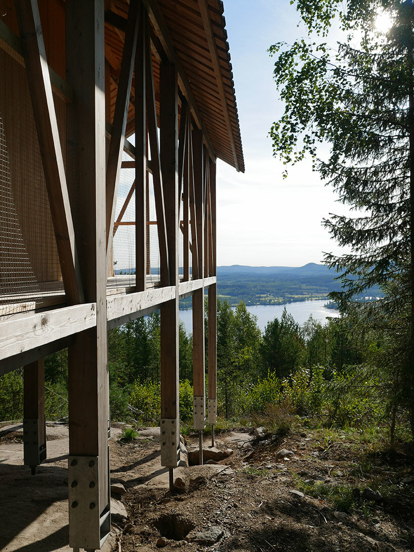 wooden cabin on stilts is perched on mountainous scenery in sweden