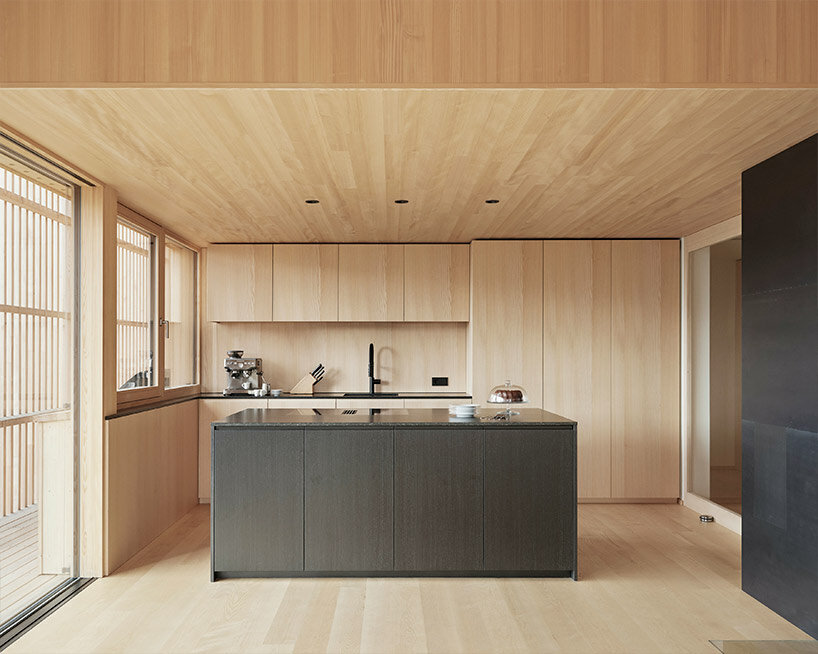 slender wooden slabs enclose permeable facade for 'multigenerational house' in rural austria