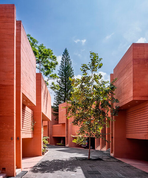 orange-tinted concrete blocks subtly stack residential complex in mexico