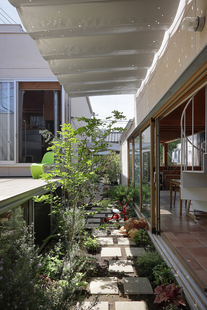 UNEMORI ARCHITECTS connects two family houses with lush garden alley in tokyo