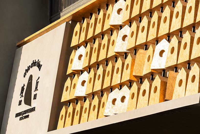 wooden roost boxes nestle on monumental columns for 'chic chic bird' noodle shop in china