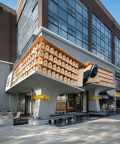 wooden roost boxes nestle on monumental columns for 'chic chic bird' noodle shop in china