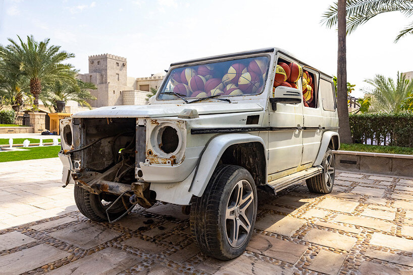 julien boudet rests giant counterfeit basketball on top of mercedes G wagon at art dubai