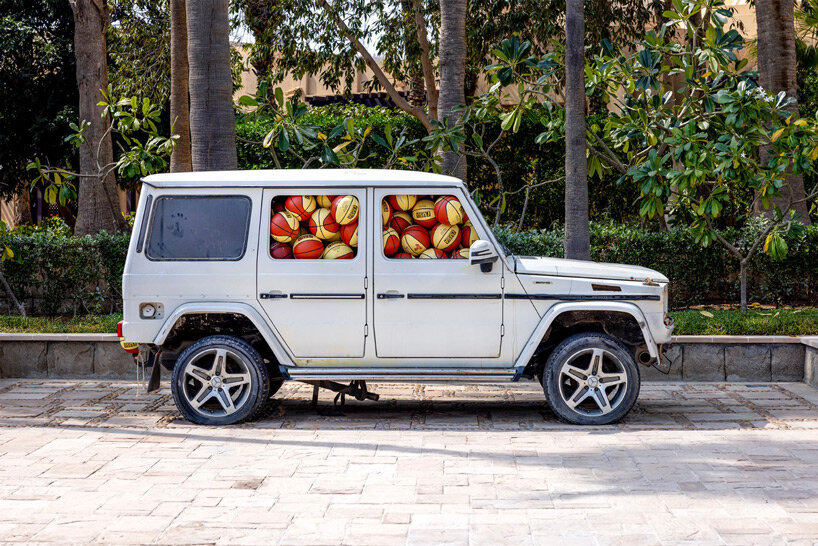 julien boudet rests giant counterfeit basketball on top of mercedes G wagon at art dubai