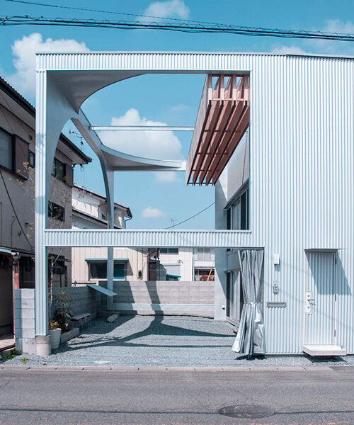 arched pergola loops over residential construction in japan covered in sheet metal