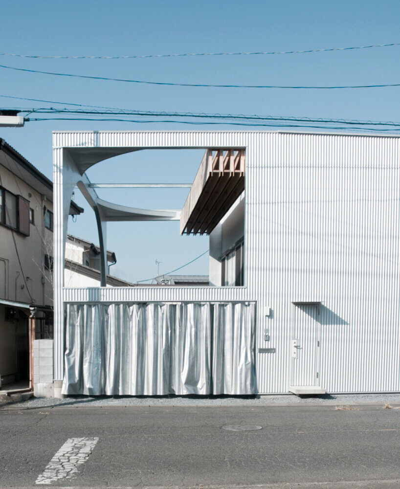 arched pergola loops over residential construction in japan covered in sheet metal
