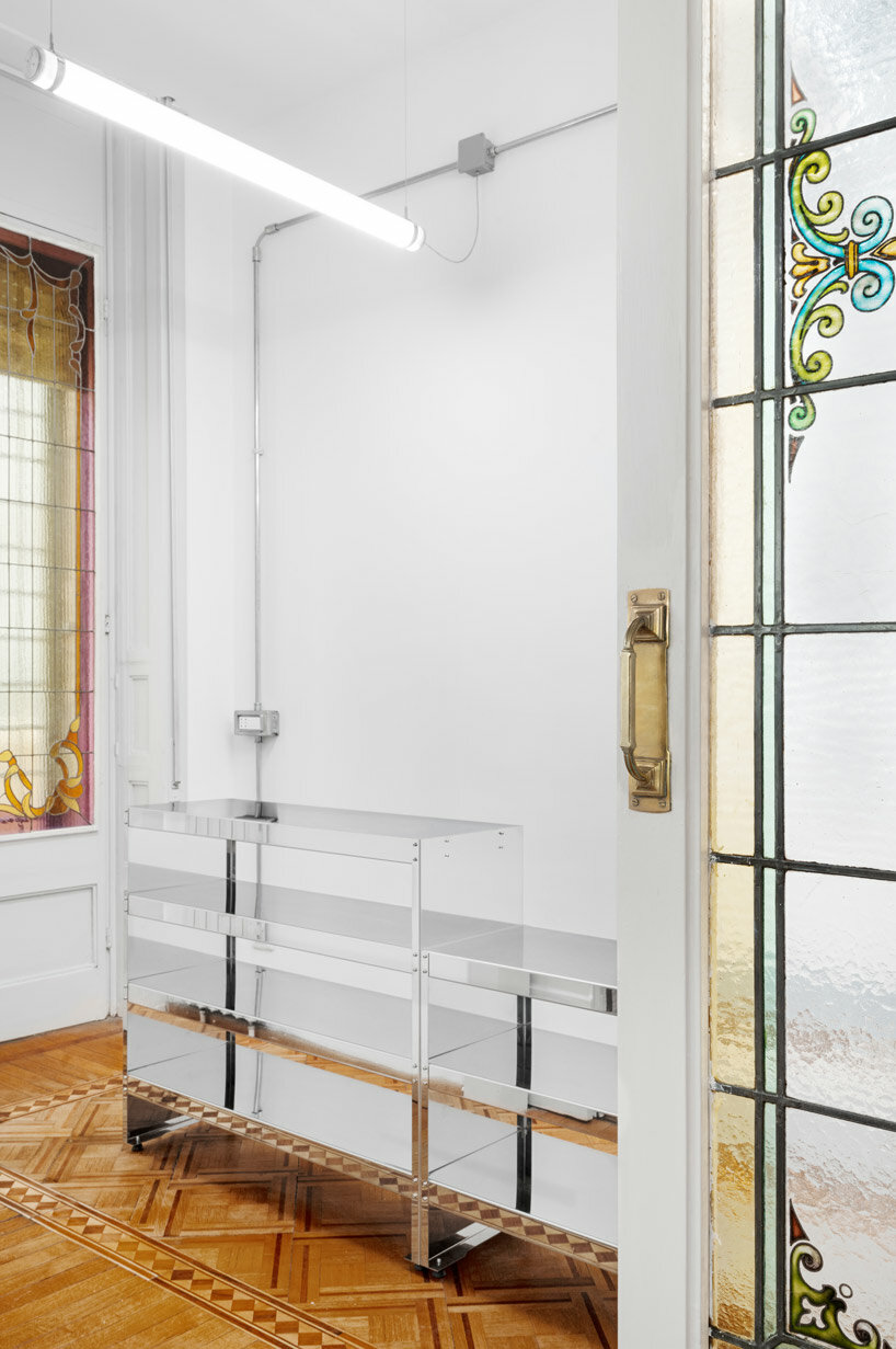 stainless steel cross ceiling + custom furniture adorn reference studios' showroom in milan