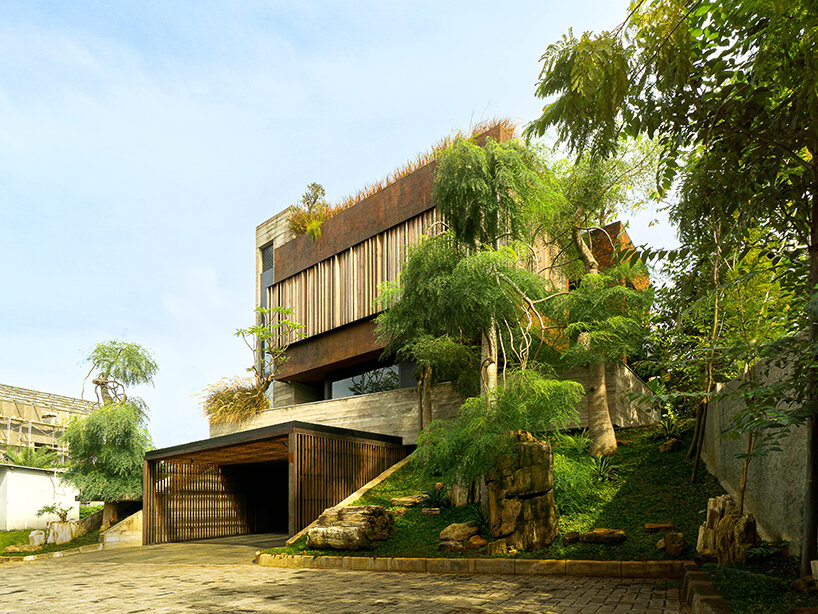 grass, stones, shrubs, and trees envelop studioRK's vibrant OHIO house in indonesia
