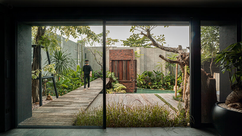 grass, stones, shrubs, and trees envelop studioRK's vibrant OHIO house in indonesia