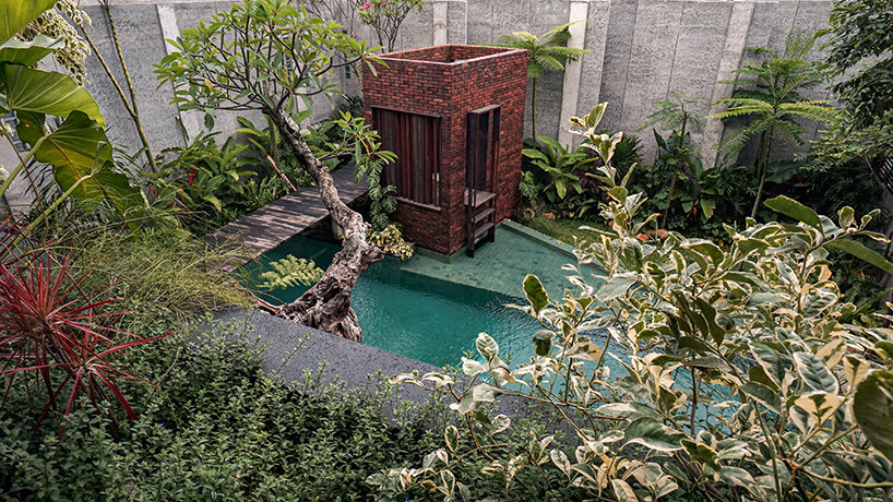 grass, stones, shrubs, and trees envelop studioRK's vibrant OHIO house in indonesia