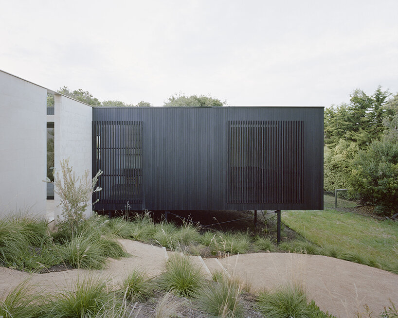 masonry blade walls & a floating timber volume compose 'peninsula house' in australia