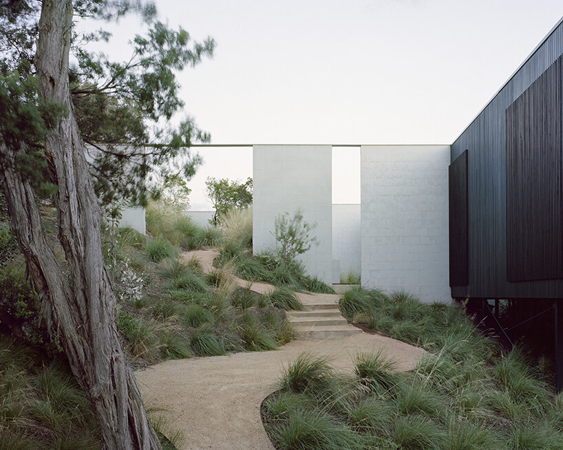 masonry blade walls & a floating timber volume compose 'peninsula house' in australia