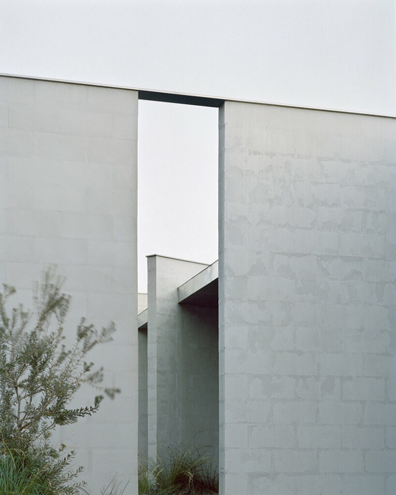 masonry blade walls & a floating timber volume compose 'peninsula house' in australia