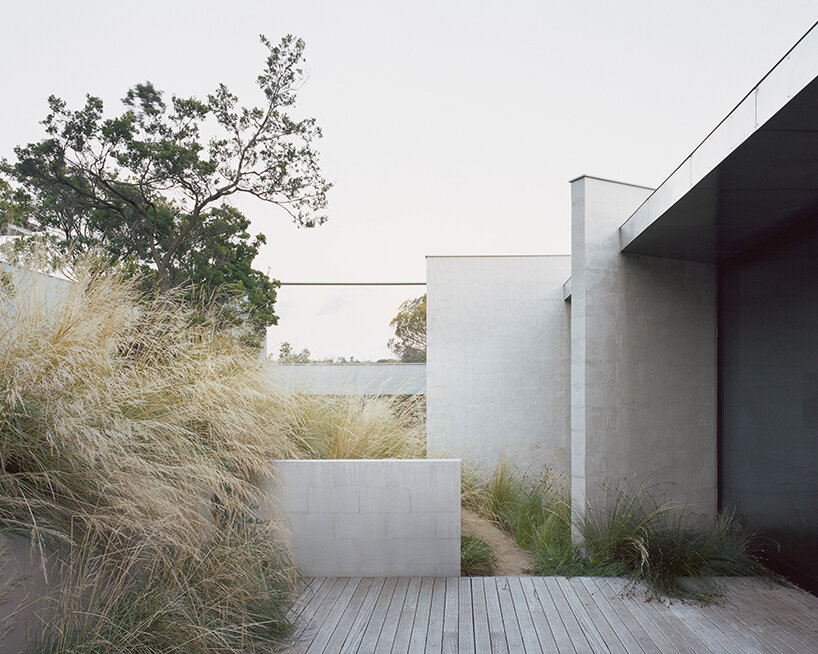 masonry blade walls & a floating timber volume compose 'peninsula house' in australia