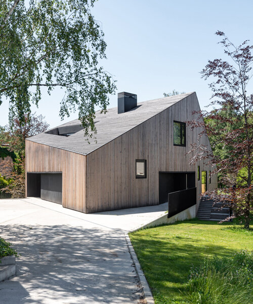 fragmented residence wraps in raw larch slats on narrow sloping plot in poland