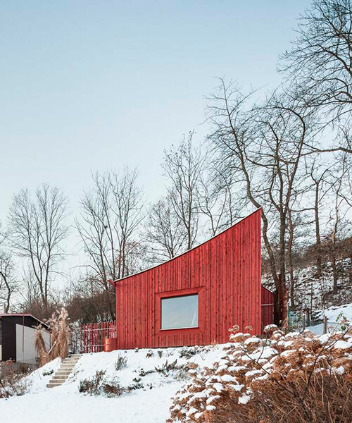 red wooden cabin's curved roof points out to the mountains of czech republic
