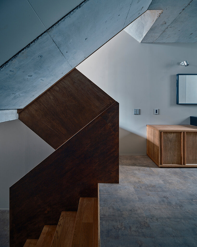 slanted lines and staggered floors create alternative spaces inside tokyo's diagonal house