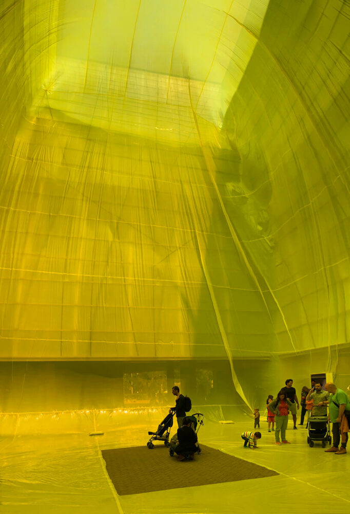 yellow inflatable installation squeezes into void space in barcelona