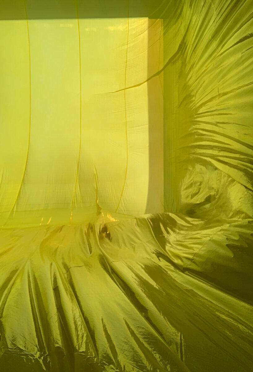 yellow inflatable installation squeezes into void space in barcelona