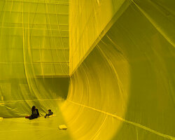 yellow inflatable installation squeezes into void space in barcelona