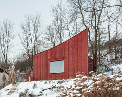 red wooden cabin's curved roof points out to the mountains of czech republic