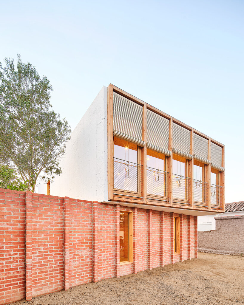 ágora arquitectura se apila en una casa de tablillas encima de un viejo zócalo de ladrillo en España