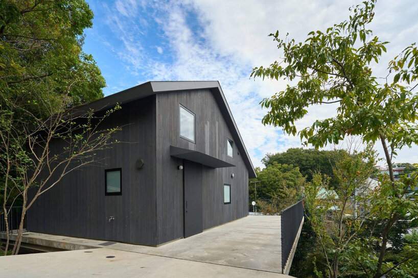 La casa in legno di Airhouse galleggia sopra un ripido pendio nella foresta giapponese 