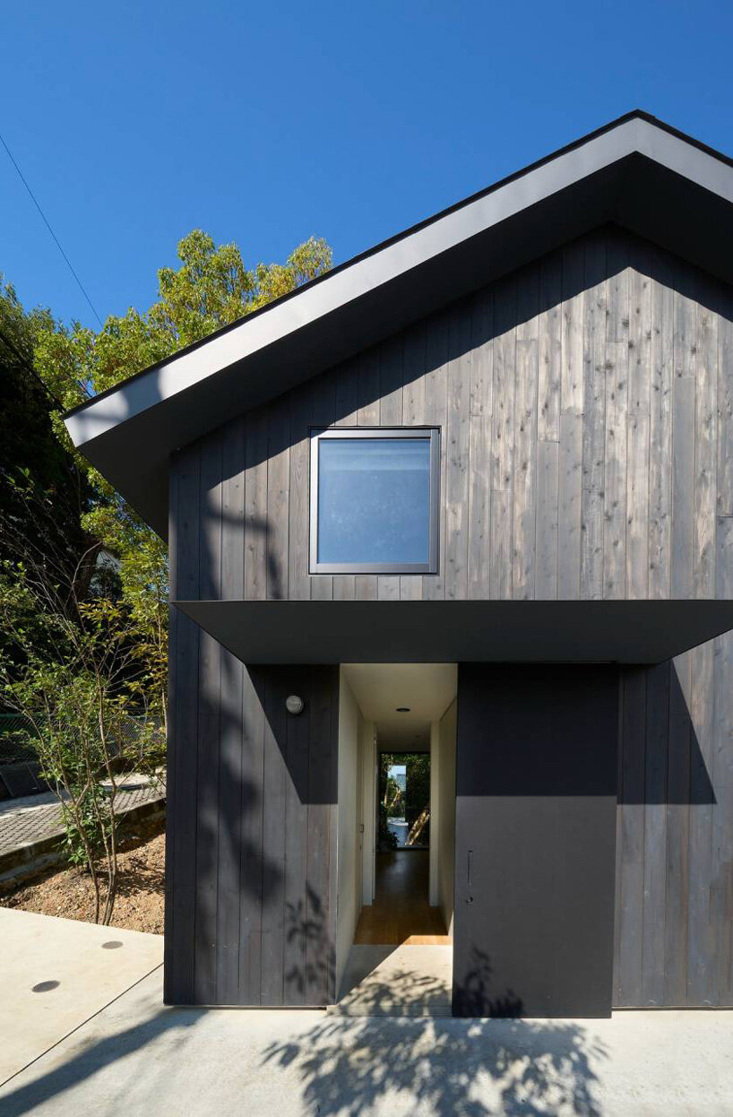 La casa in legno di Airhouse galleggia sopra un ripido pendio nella foresta giapponese 