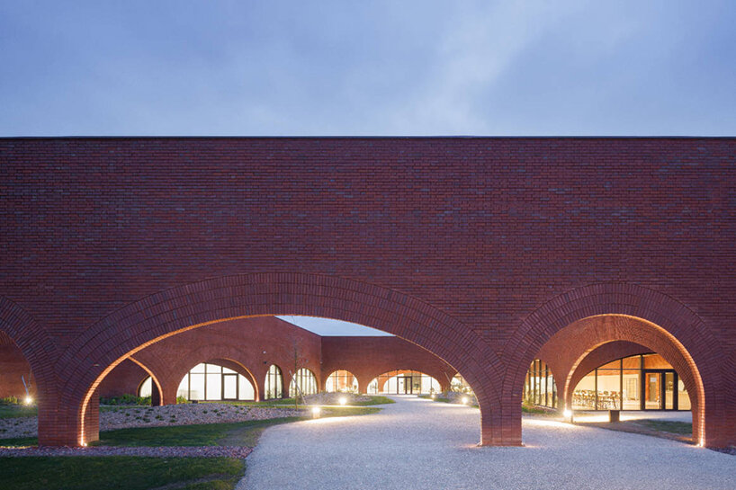 lina ghotmeh brings sweeping arches to brick-clad hermès workshop in normandy