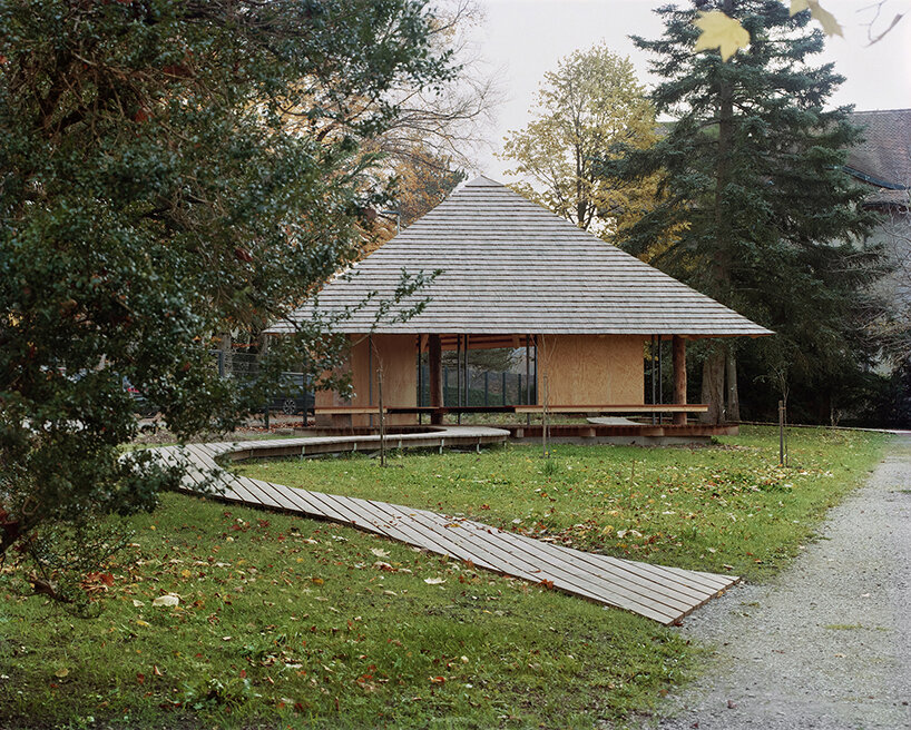 charly jolliet's umbrella-shaped canopy in switzerland spotlights traditional wood cladding