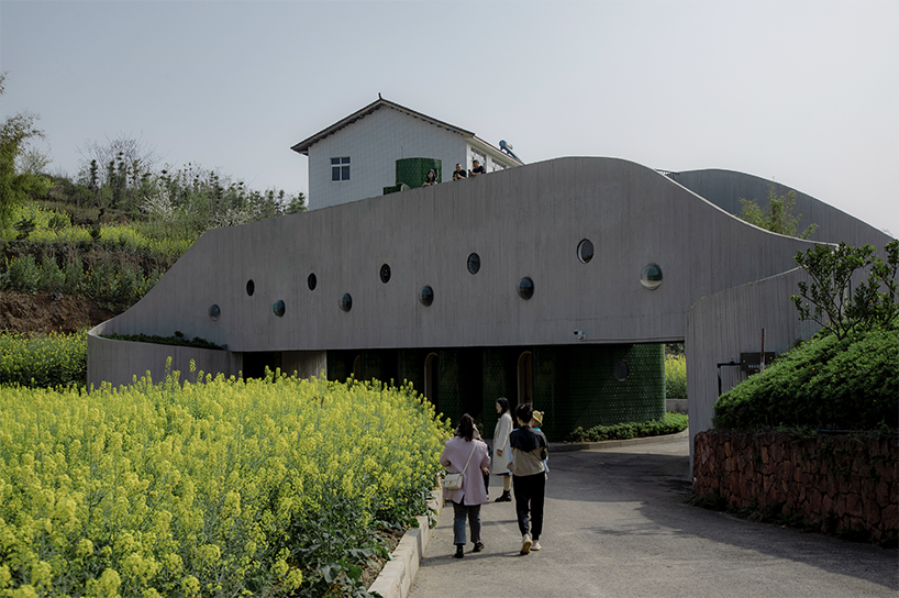 folded agricultural complex doubles as bridge and public toilet in rural china