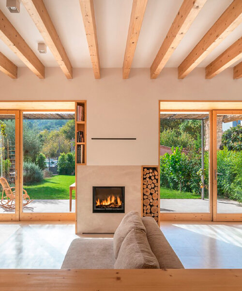 eco-passive house in spain exposes its wooden frame along with natural stone elements